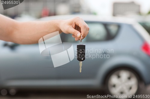 Image of man with car key outside