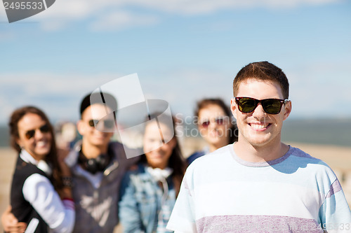 Image of teenager in shades outside with friends