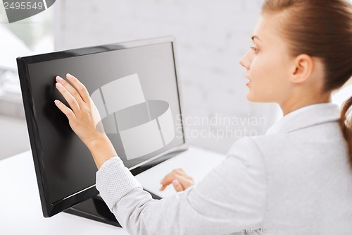 Image of smiling businesswoman with touchscreen in office