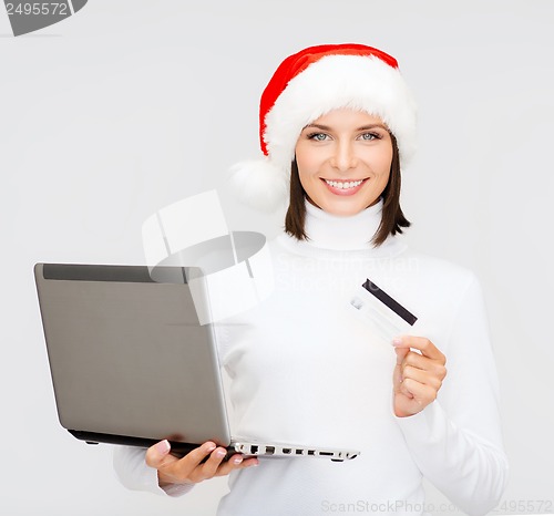 Image of woman in santa hat with laptop and credit card