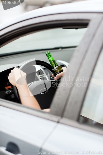 Image of man drinking alcohol while driving the car