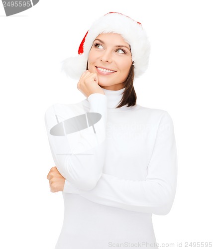 Image of thinking and smiling woman in santa helper hat