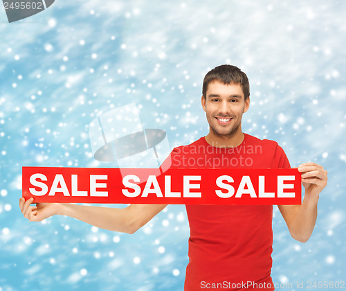 Image of smiling man in red shirt with sale sign