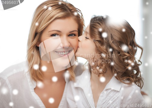 Image of happy daughter kisses her mother