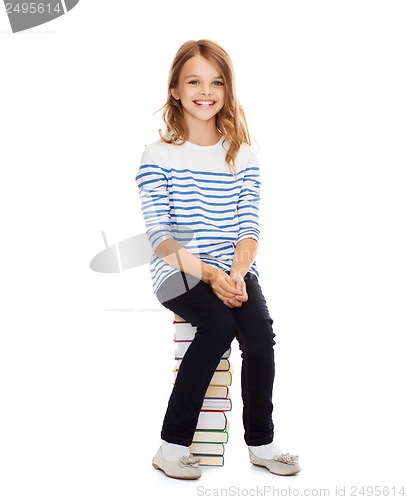 Image of little student girl sitting on stack of books