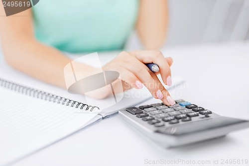 Image of businesswoman working with calculator in office