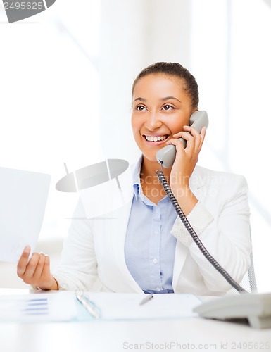 Image of african businesswoman with phone in office