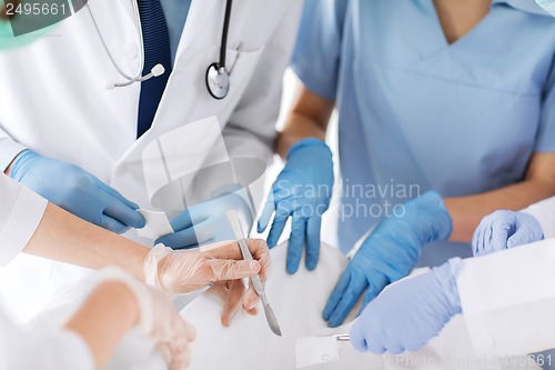 Image of young group of doctors doing operation