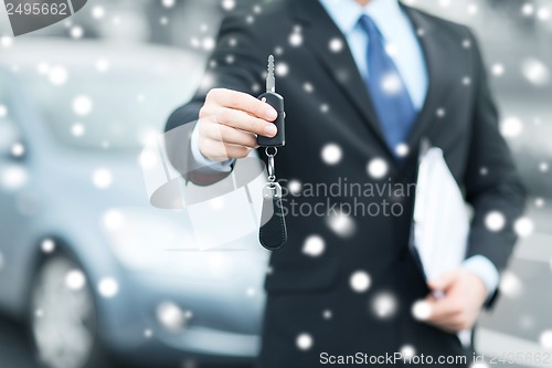 Image of man with car key outside