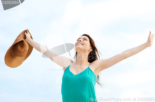 Image of girl with hands up on the beach