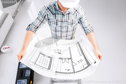 Image of male architect in helmet with blueprint