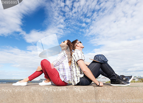 Image of teenagers sitting back to back