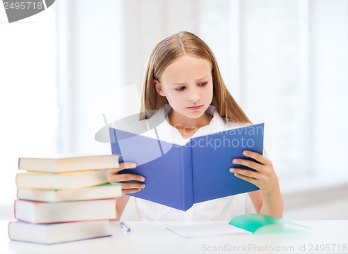Image of girl studying and reading book at school