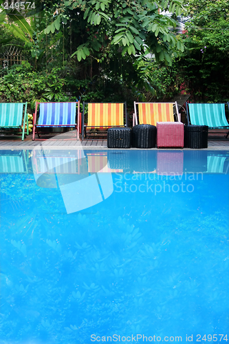 Image of Deck chairs next to a pool