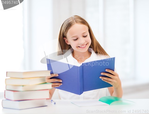 Image of girl studying and reading book at school