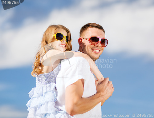 Image of happy father and child in sunglasses over blue sky