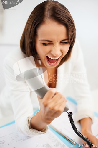 Image of woman shouting into phone in office