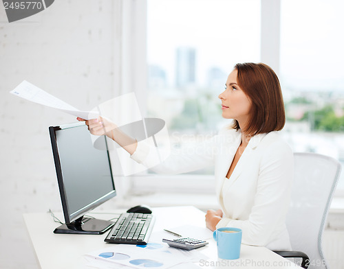 Image of businesswoman giving papers in office