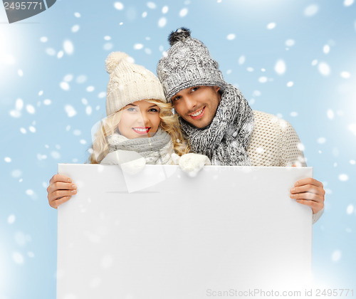 Image of couple in a winter clothes holding blank board