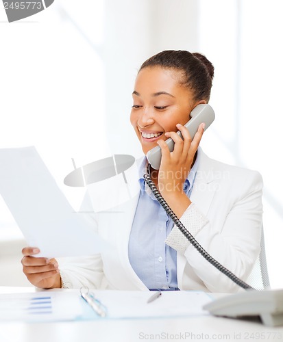 Image of african businesswoman with phone in office