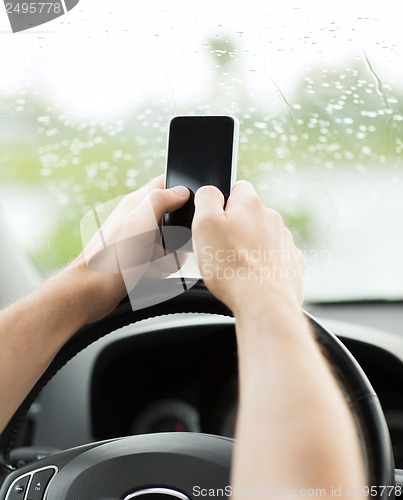 Image of man using phone while driving the car