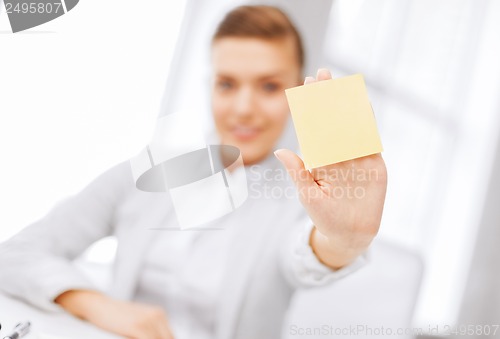 Image of smiling businesswoman showing sticky note