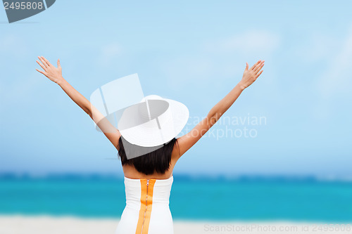 Image of girl with hands up on the beach