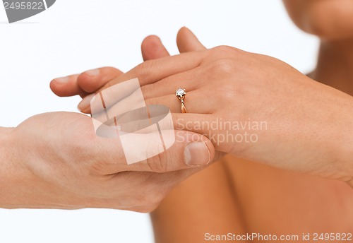 Image of man puts wedding ring on woman hand