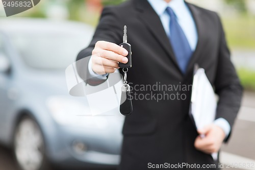 Image of man with car key outside