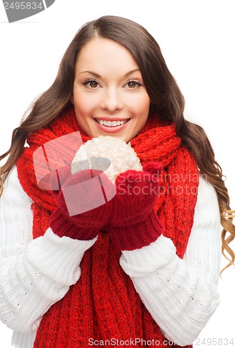 Image of woman in scarf and mittens with christmas ball