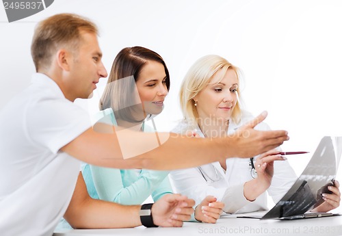 Image of doctor with patients looking at x-ray