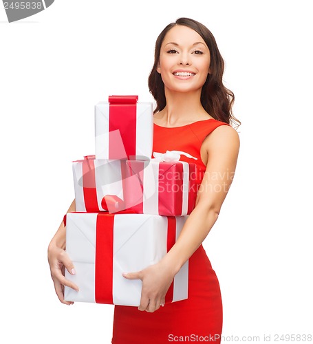 Image of smiling woman in red dress with many gift boxes