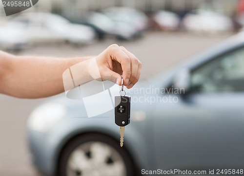 Image of man with car key outside