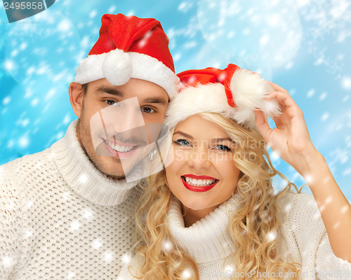 Image of family couple in sweaters and santa's hats