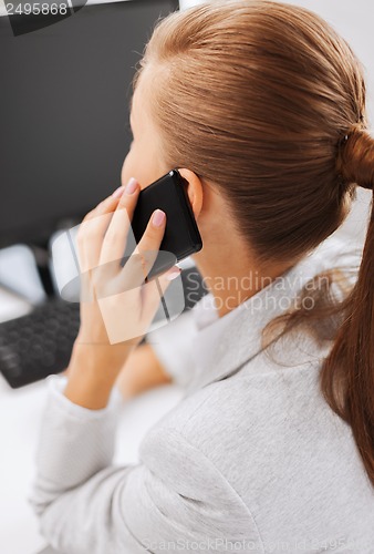 Image of businesswoman with smartphone in office