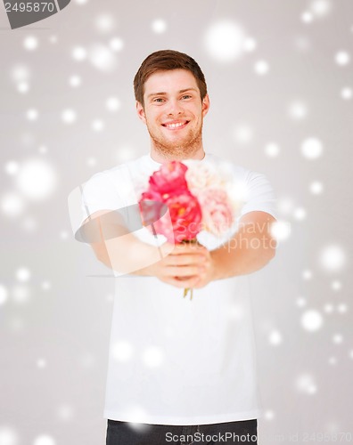 Image of young man holding bouquet of flowers