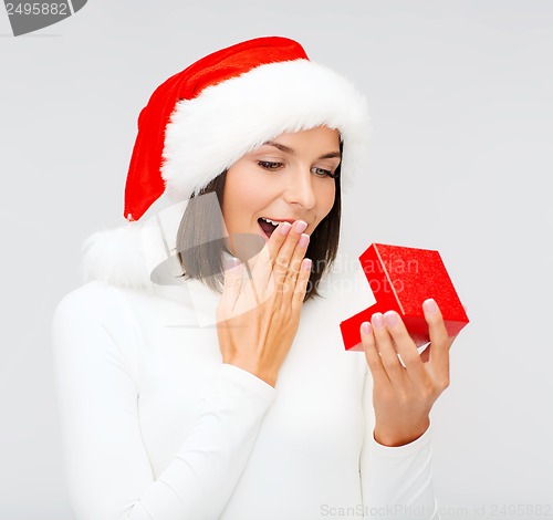 Image of surprised woman in santa helper hat with gift box