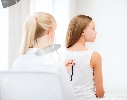 Image of doctor with stethoscope listening to child back