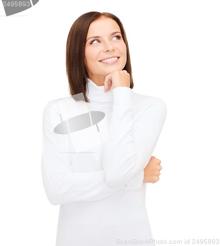 Image of thinking and smiling woman in white sweater