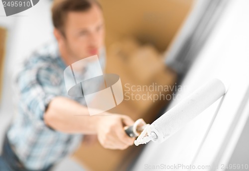 Image of man colouring the wall with roller