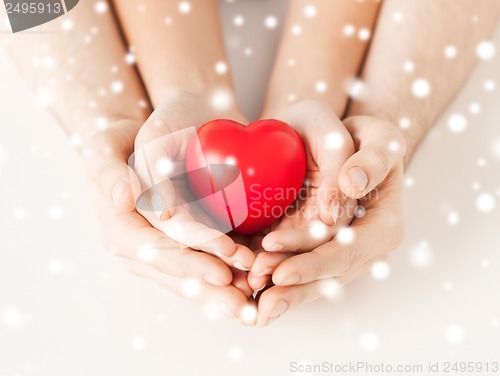 Image of woman and man hands with heart