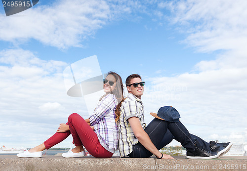 Image of teenagers sitting back to back