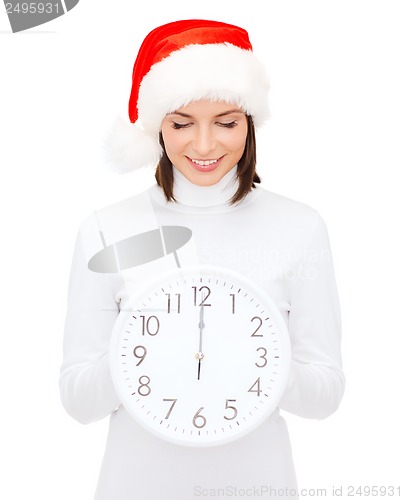 Image of woman in santa helper hat with clock showing 12