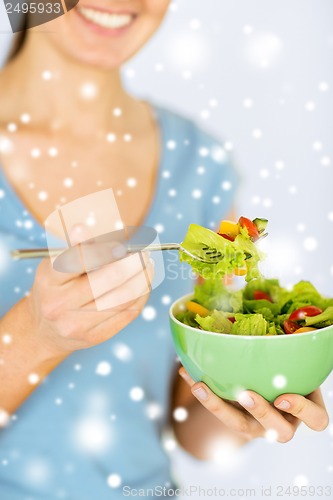 Image of woman eating salad with vegetables