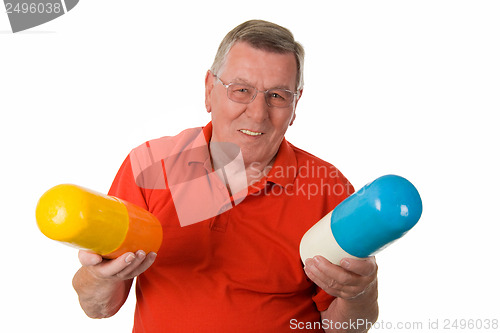 Image of Old man holding big pills