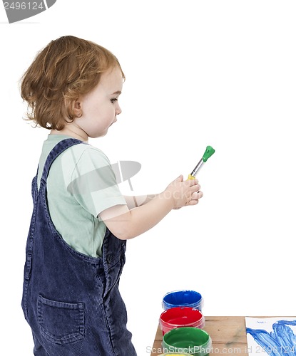 Image of child with brush and green paint