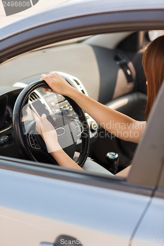 Image of woman using phone while driving the car