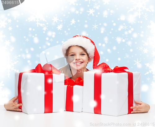 Image of girl in santa helper hat with many gift boxes