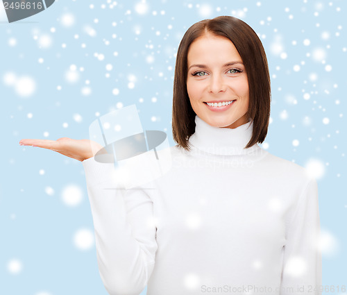 Image of woman in white sweater with something on palm