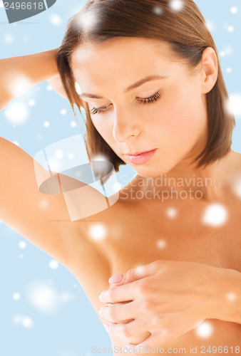 Image of woman checking breast for signs of cancer